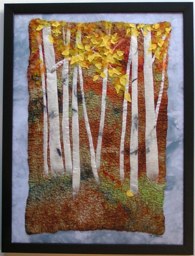 Framed textile artwork depicting birch trees in autumn.